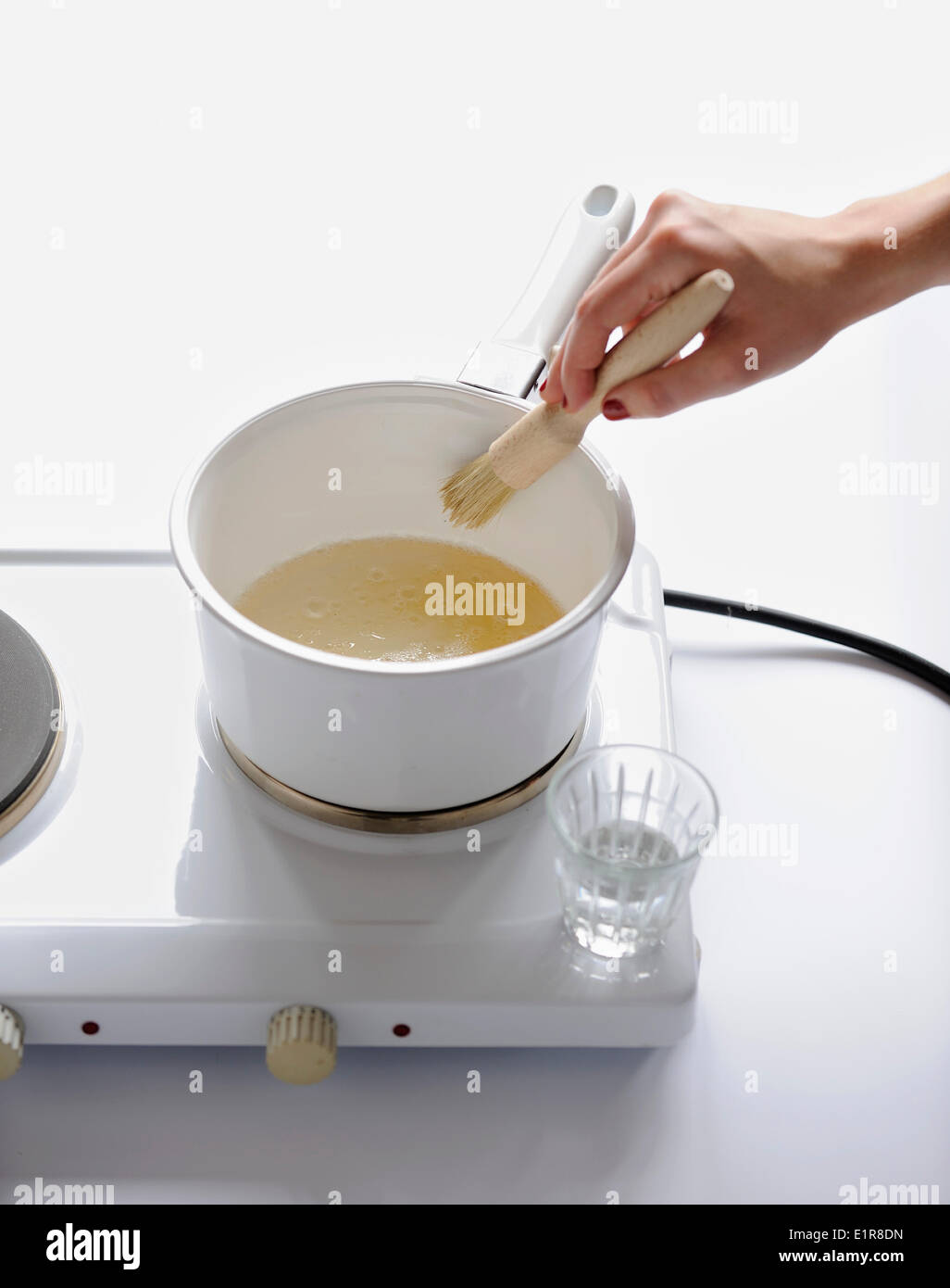 Wetting the sides of the saucepan with water Stock Photo