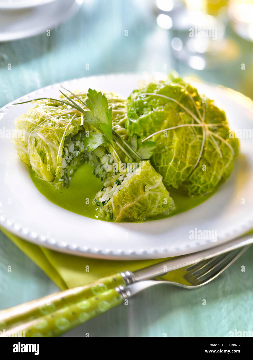 Cabbage leaves stuffed with whiting and sorrel,green parsley sauce Stock Photo