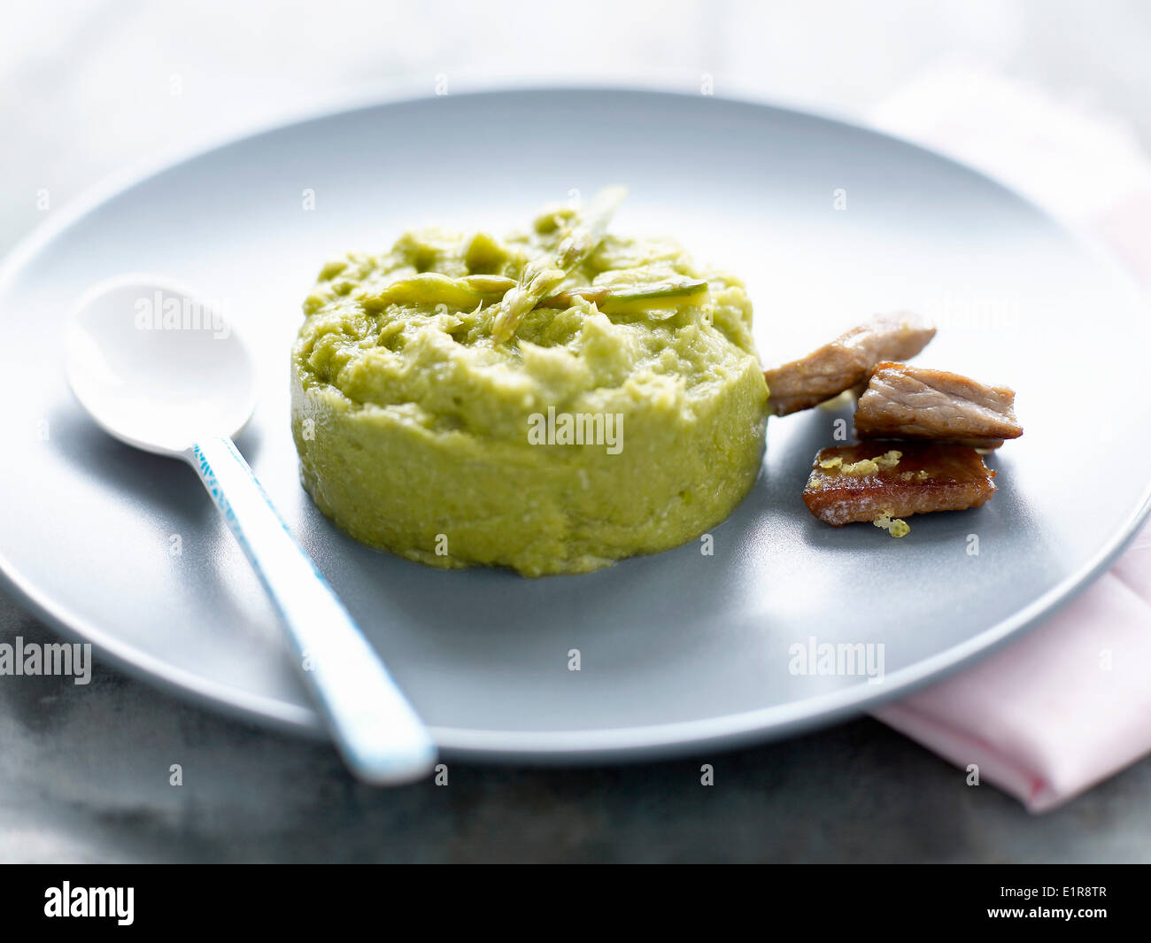 Mashed zucchinis and asparagus,small pieces of pork Stock Photo