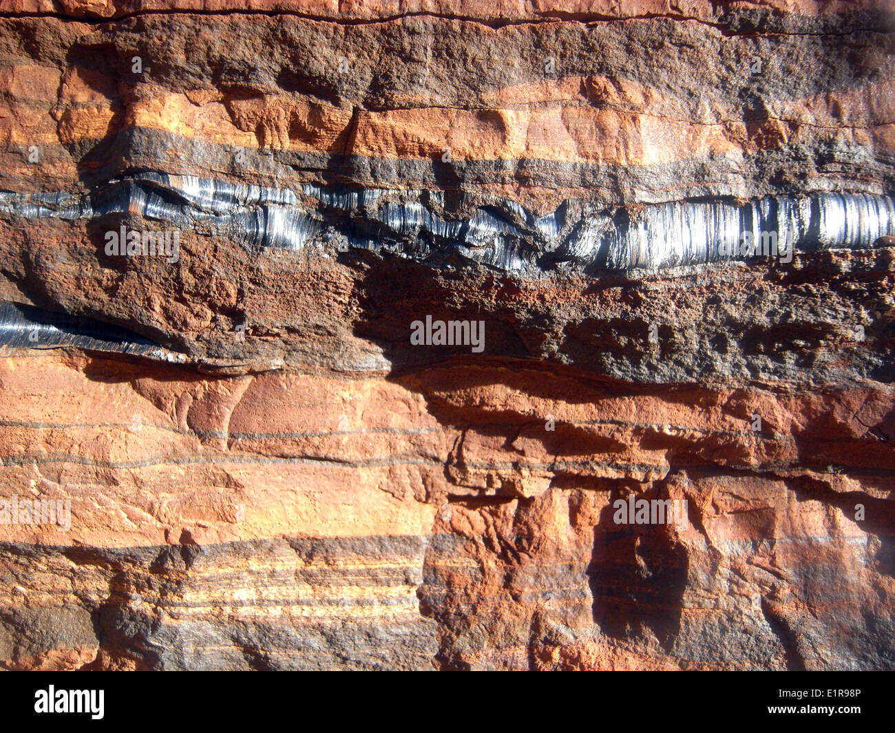 Vein of blue asbestos in banded ironstone rocks, Karijini National Park, Hamersley Range, Pilbara, Western Australia Stock Photo