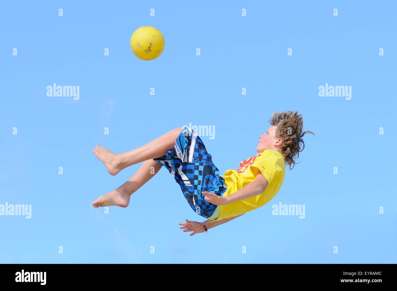 Boy makes bicycle kick in the air Stock Photo