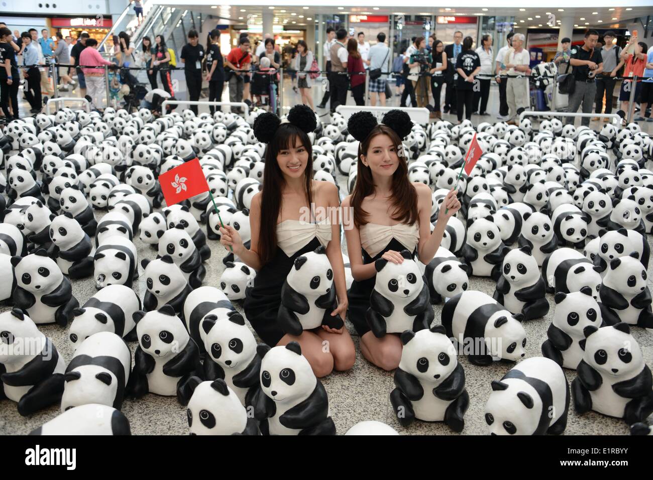 Hong Kong. 9th June, 2014. Two models pose with paper pandas at Hong Kong International Airport in Hong Kong, south China, June 9, 2014. The 1600 paper pandas would be displayed at some view spots in Hong Kong from June 9 to 21. Credit:  Xinhua/Alamy Live News Stock Photo