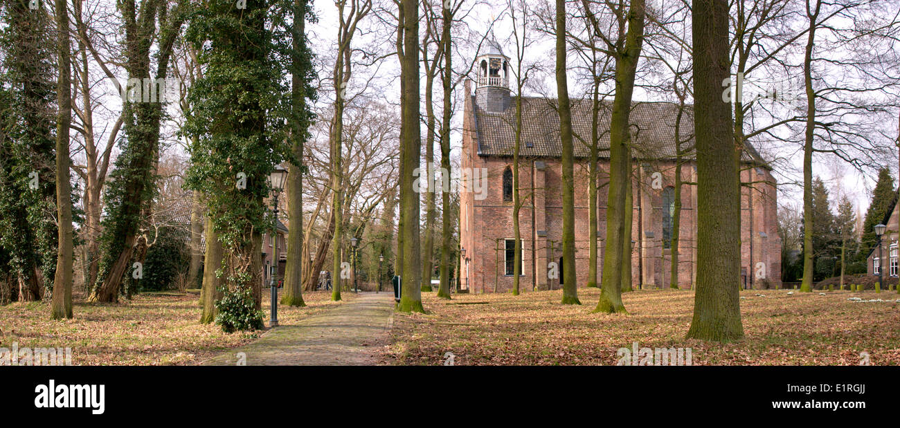 The village church of Diepenveen surrounded by oak trees on a historic cemetery. Stock Photo