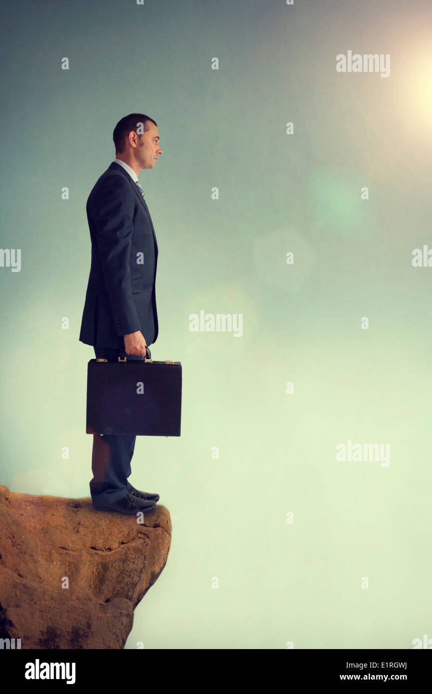 businessman standing on the edge or precipice or brink of a mountain Stock Photo