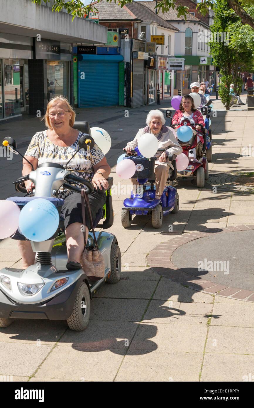 Group of people  do a charity fun run in aid of Southampton Hospital on decorated mobility scooters. Stock Photo