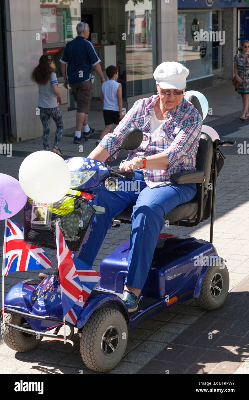 Person on decorated mobility scooter taking part in a charity 'fun run'. Stock Photo
