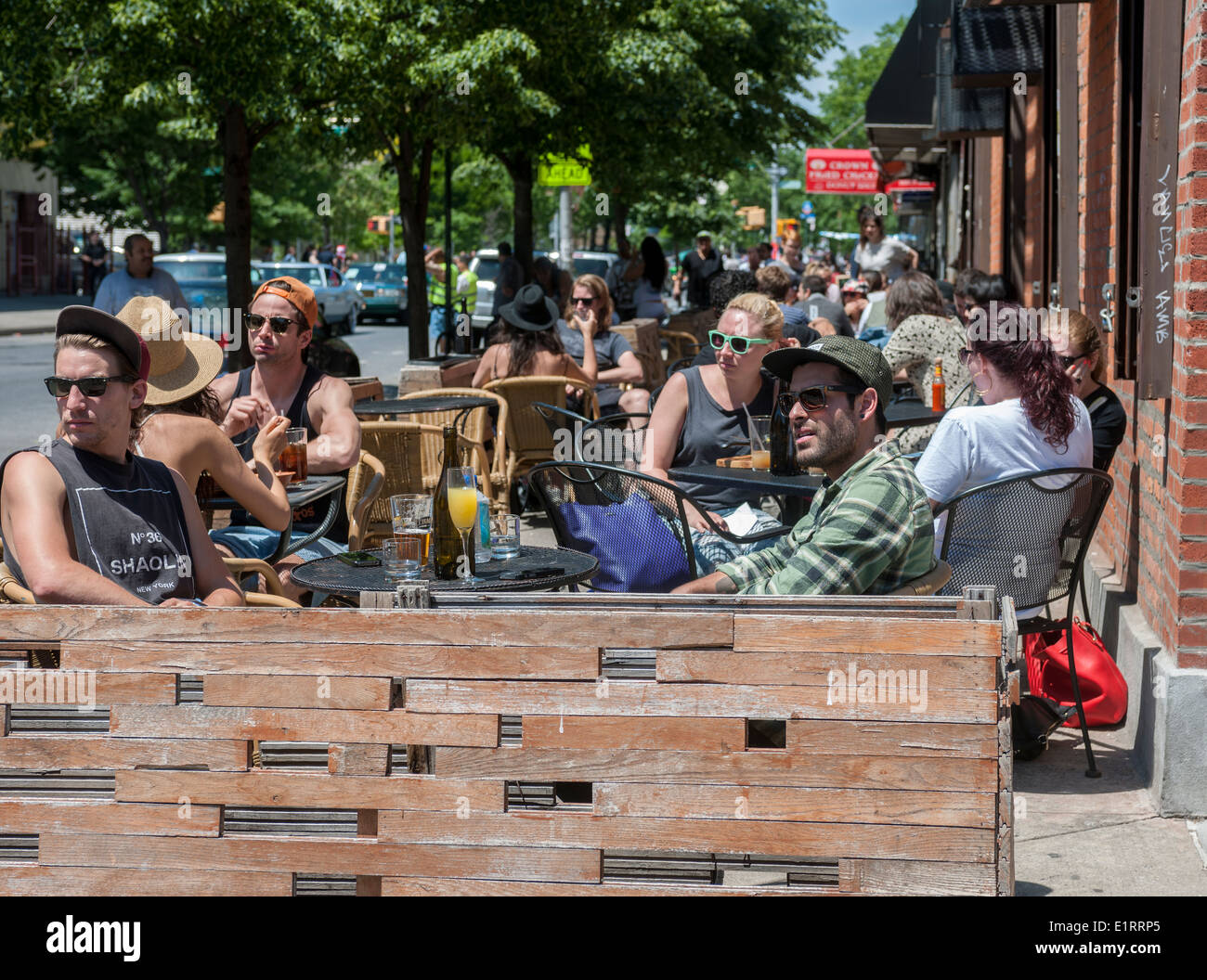 Hipsters brunch in an outdoor cafe on busy Graham Avenue in the Bushwick neighborhood of Brooklyn in New York Stock Photo