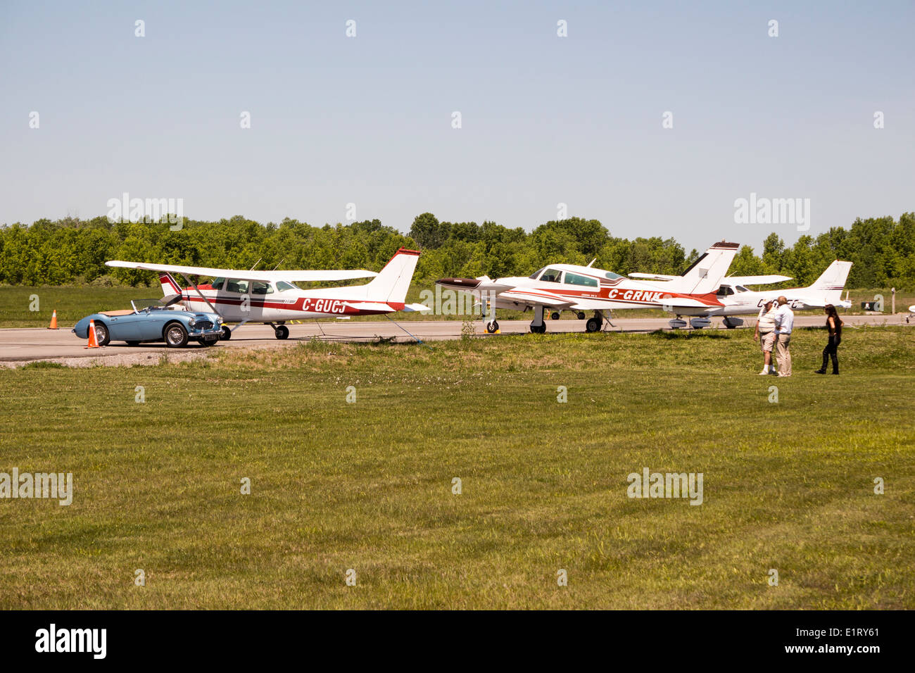 1961 BT7 Austin Healey 3000 Mark II 2+2 parked next to planes at a local small airport in Lindsay, Kawartha Lakes, Ontario Stock Photo