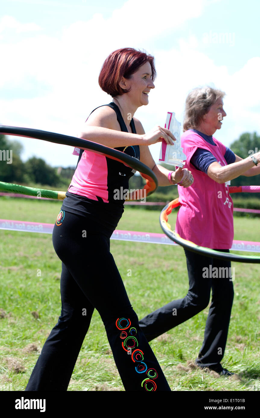 Race for Life, Cancer Research UK charity event, hula hoopers completing the course. Stock Photo