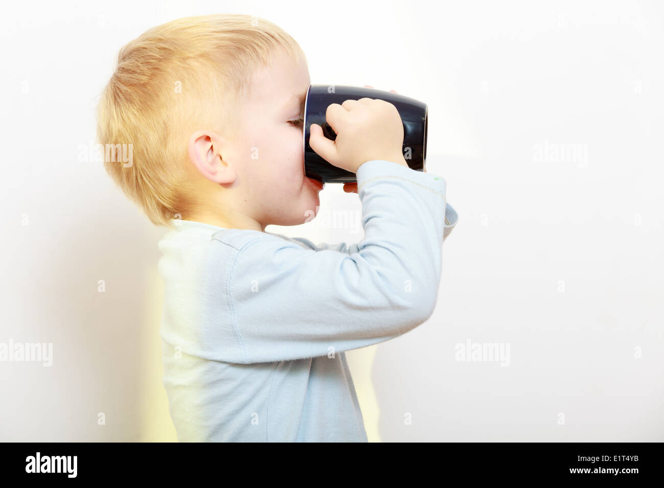 Happy childhood. Funny little boy child kid drinking tea. Indoor Stock