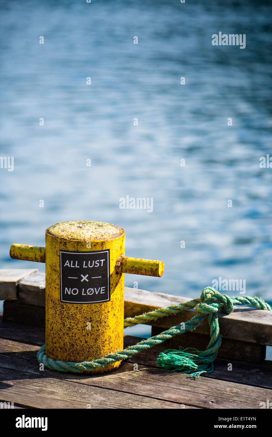 Colourful mooring bollard with an interesting message. Found in Flåm in Norway. Stock Photo