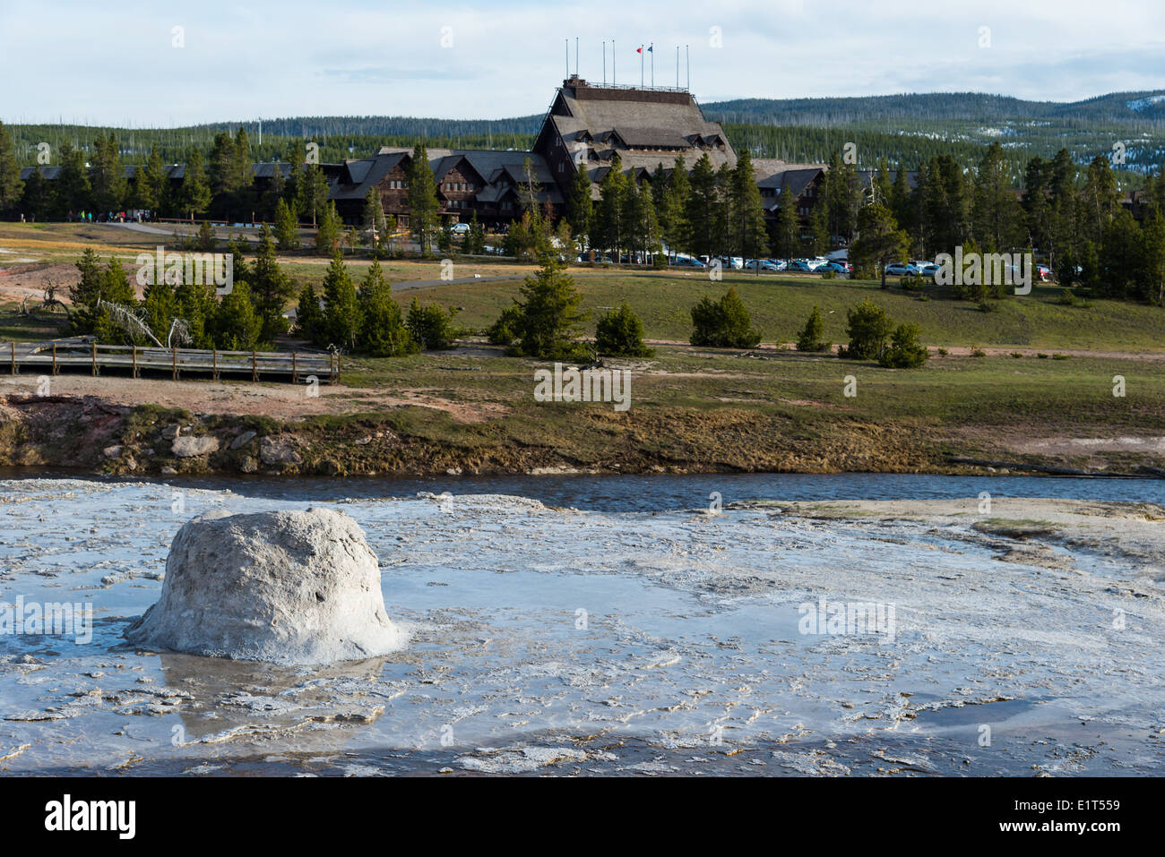 The Beehive Geyser, with Old Faithful Inn in background. Yellowstone National Park, Wyoming, USA. Stock Photo