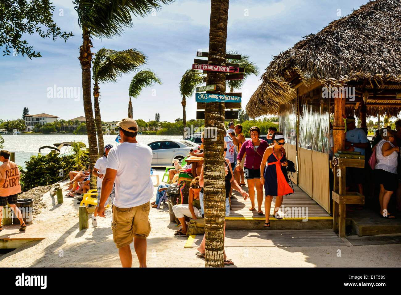 Patrons enjoying a Happy hour in full swing at a thatched roof coastal