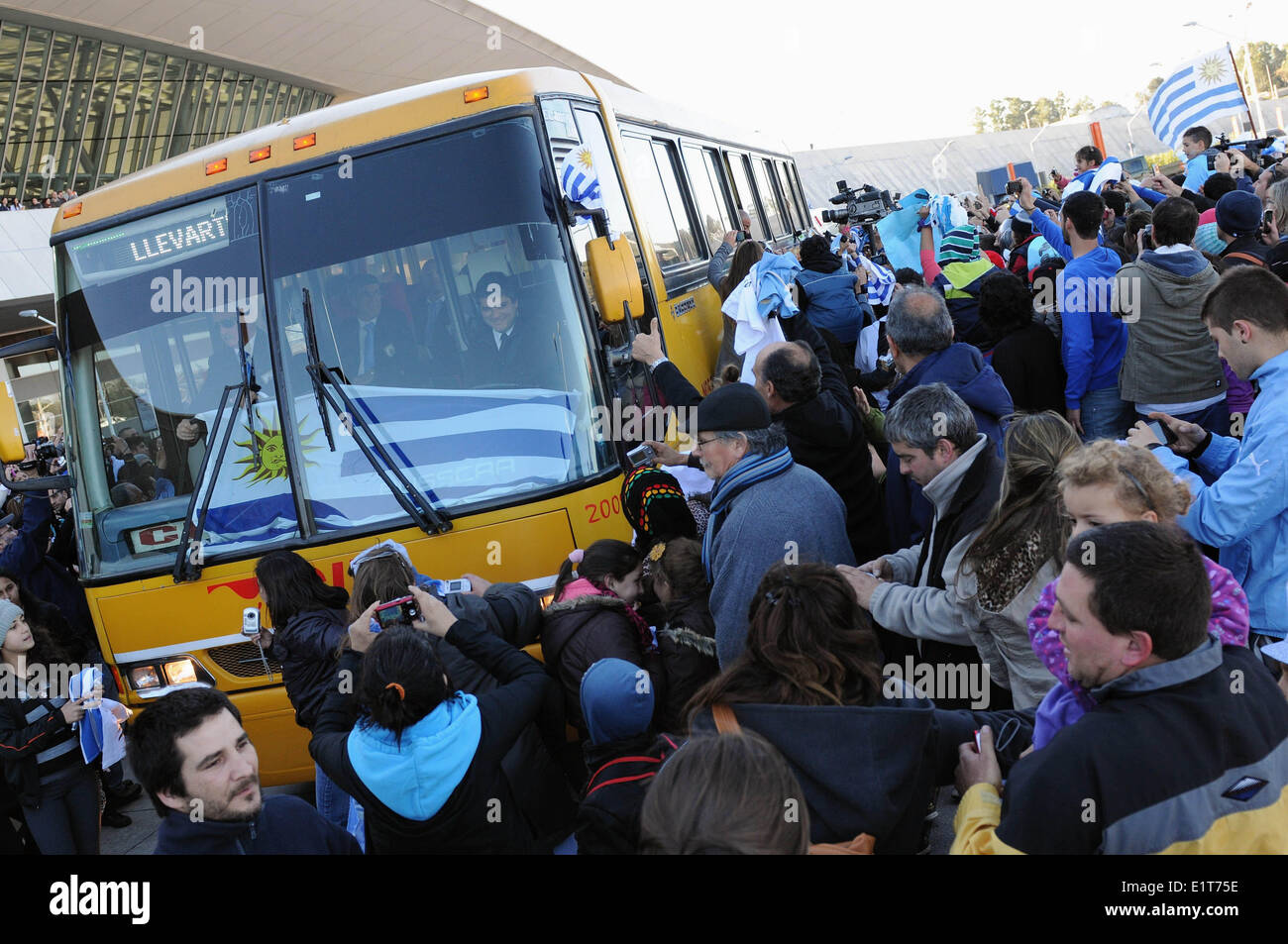 Montevideo, Uruguay. 9th June, 2014. Supporters of Uruguay's national soccer team gather around the bus carring players before their departure to the 2014 FIFA World Cup Brazil, in the Carrasco International Airport, in Montevideo, capital of Uruguay, on June 9, 2014. Credit:  Nicolas Celaya/Xinhua/Alamy Live News Stock Photo