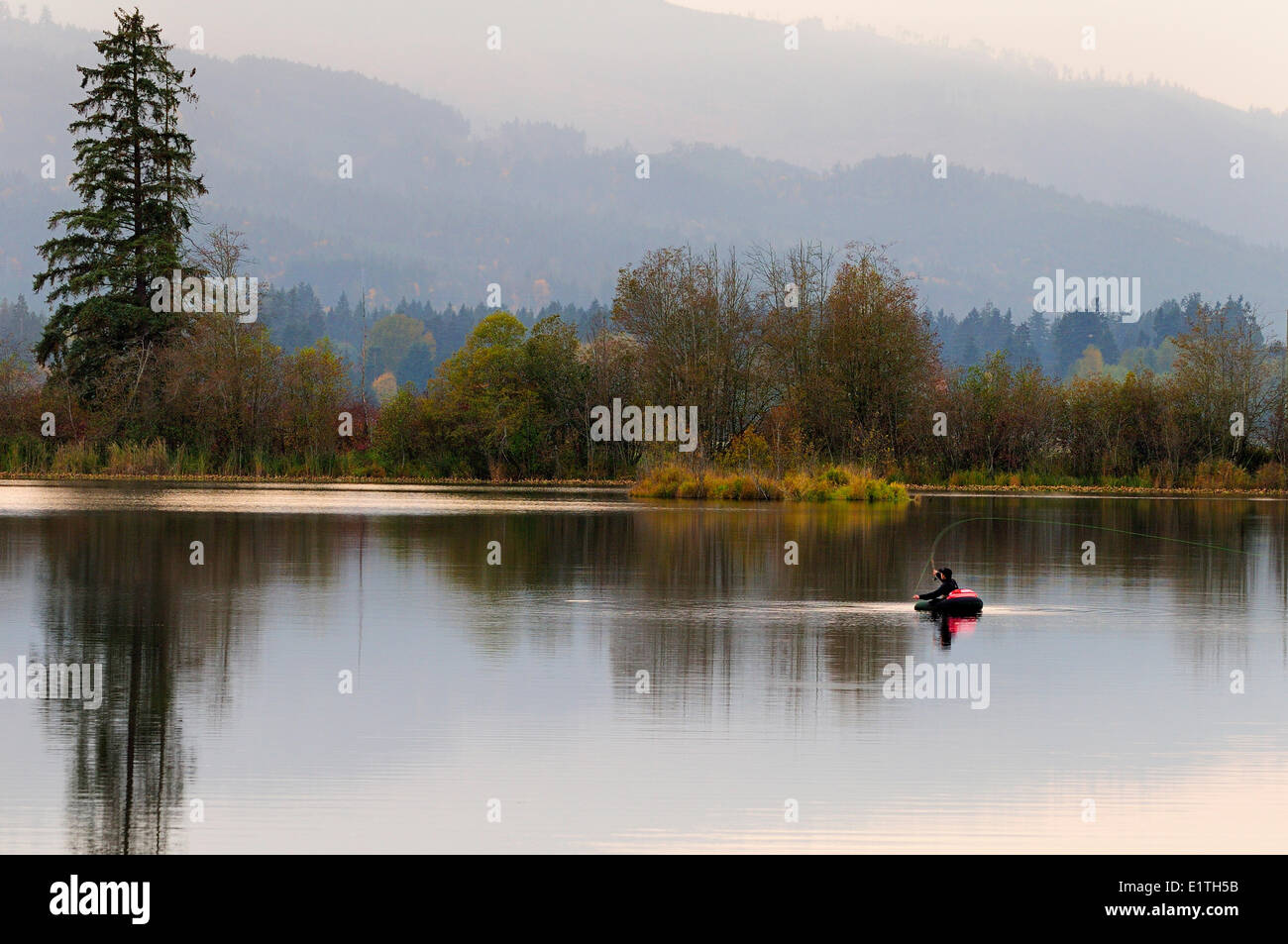 A man fly fishing in a float tube on Dougan Lake near Cobble Hill, BC