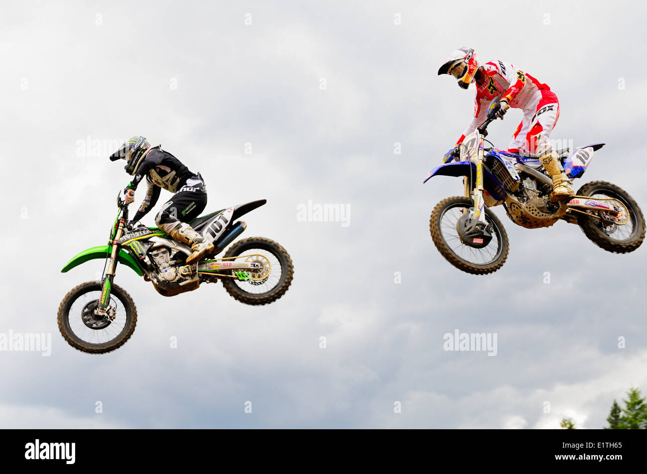 Two motocross riders, #101 and #10, are airborne after a jump at the Monster Energy Motocross Nationals at the Wastelands track Stock Photo