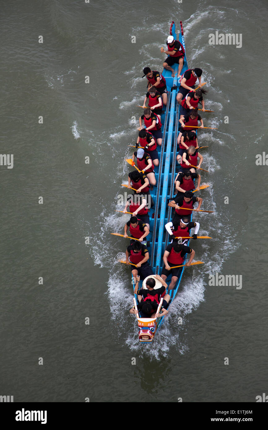 A competing team paddles down the river at the annual Dragon Boat Festival race in Taipei, Taiwan, Saturday, May 31, 2014. Dragon boat races are held across Southeast Asia for more than 2000 years to remember Qu Yuan, an ancient Chinese poet and minister, Stock Photo