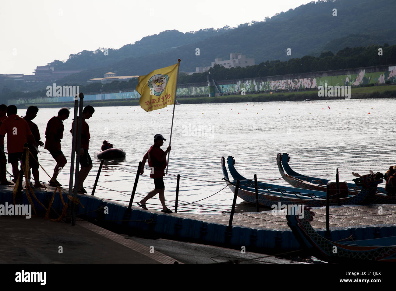Members of a dragon boat race team head to their boat for the start at the annual Dragon Boat Festival in Taipei, Taiwan, Saturday, May 31, 2014. Dragon boat races are held across the Southeast Asia for more than 2000 years to remember Qu Yuan, an ancient Stock Photo