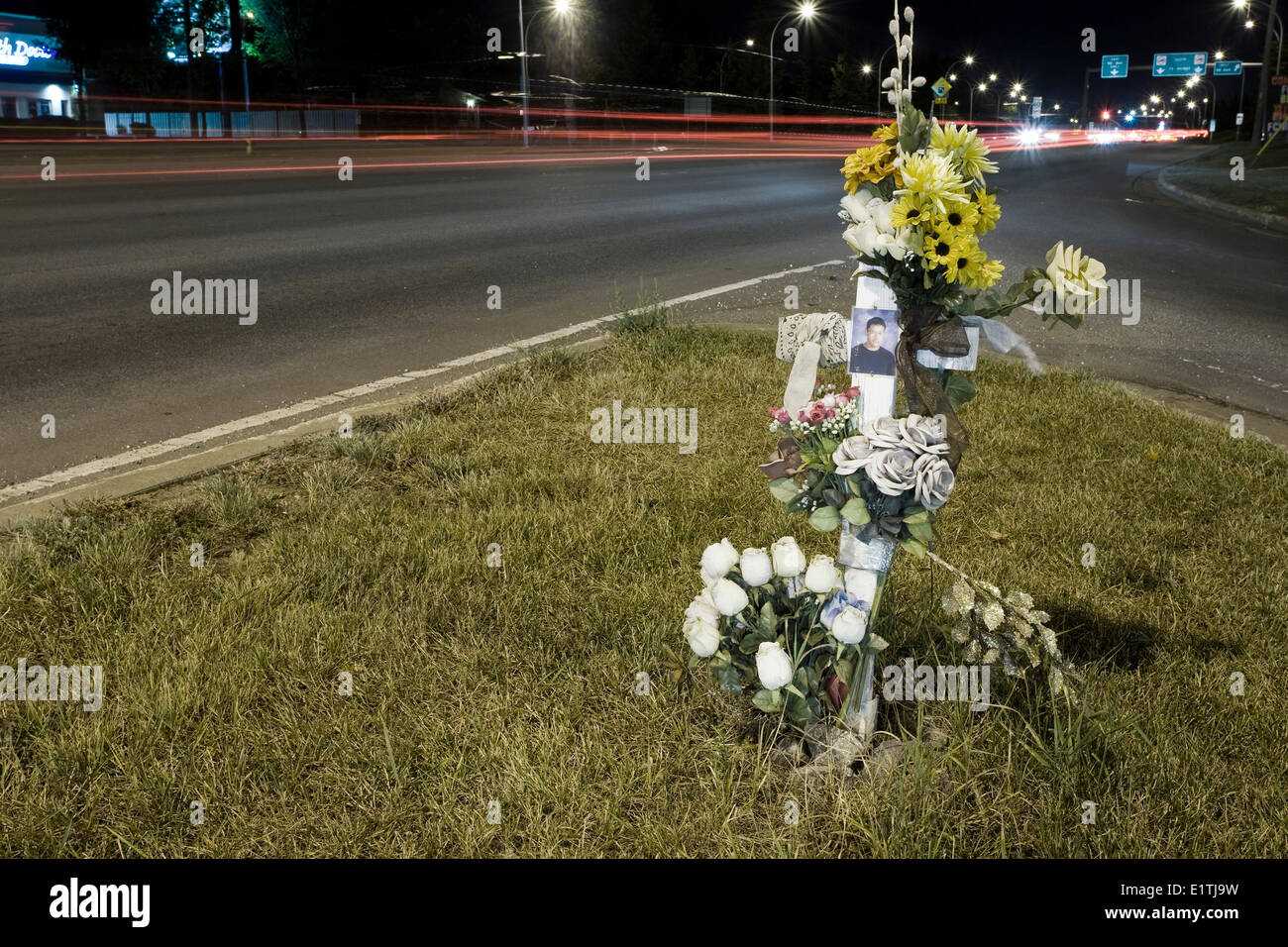 Road side cross at urban intersection memorial for traffic death. Stock Photo
