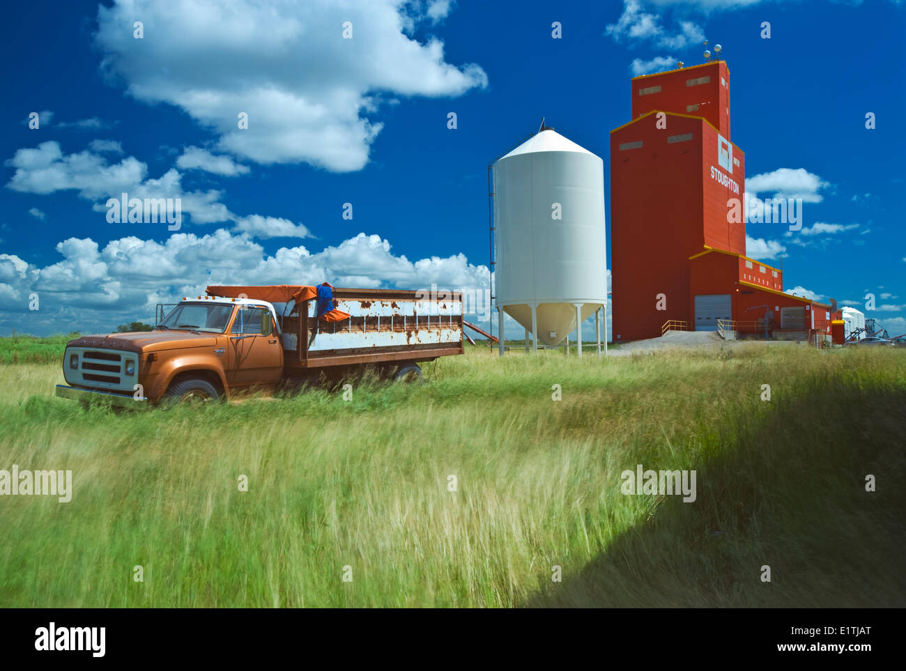 wind blown grass, old truck, grain elevator, Stoughton, Saskatchewan, Canada Stock Photo