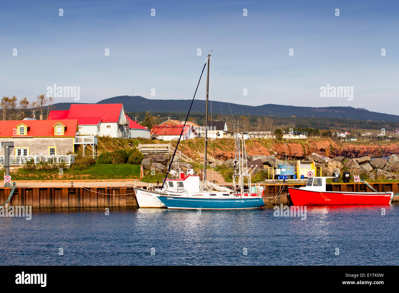 Motor boat and sailboat tied up at wharf, L'Anse-a-Beaufils, Gaspe, Quebec, Canada Stock Photo