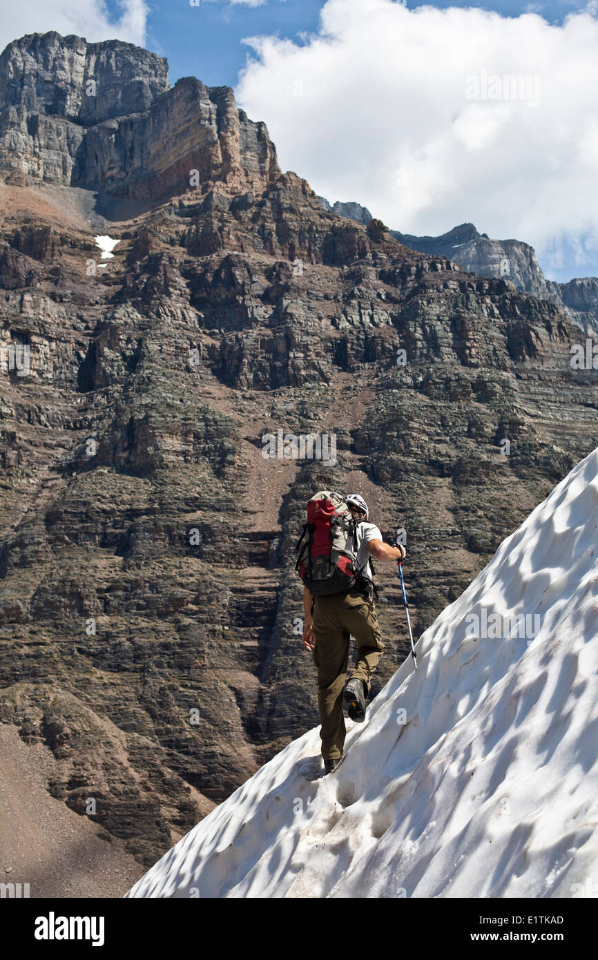 A male rockclimber crosses a snow field after some alpine rockclimbing Grand Sentinel 10d Moraine Lake Banff National Park AB Stock Photo