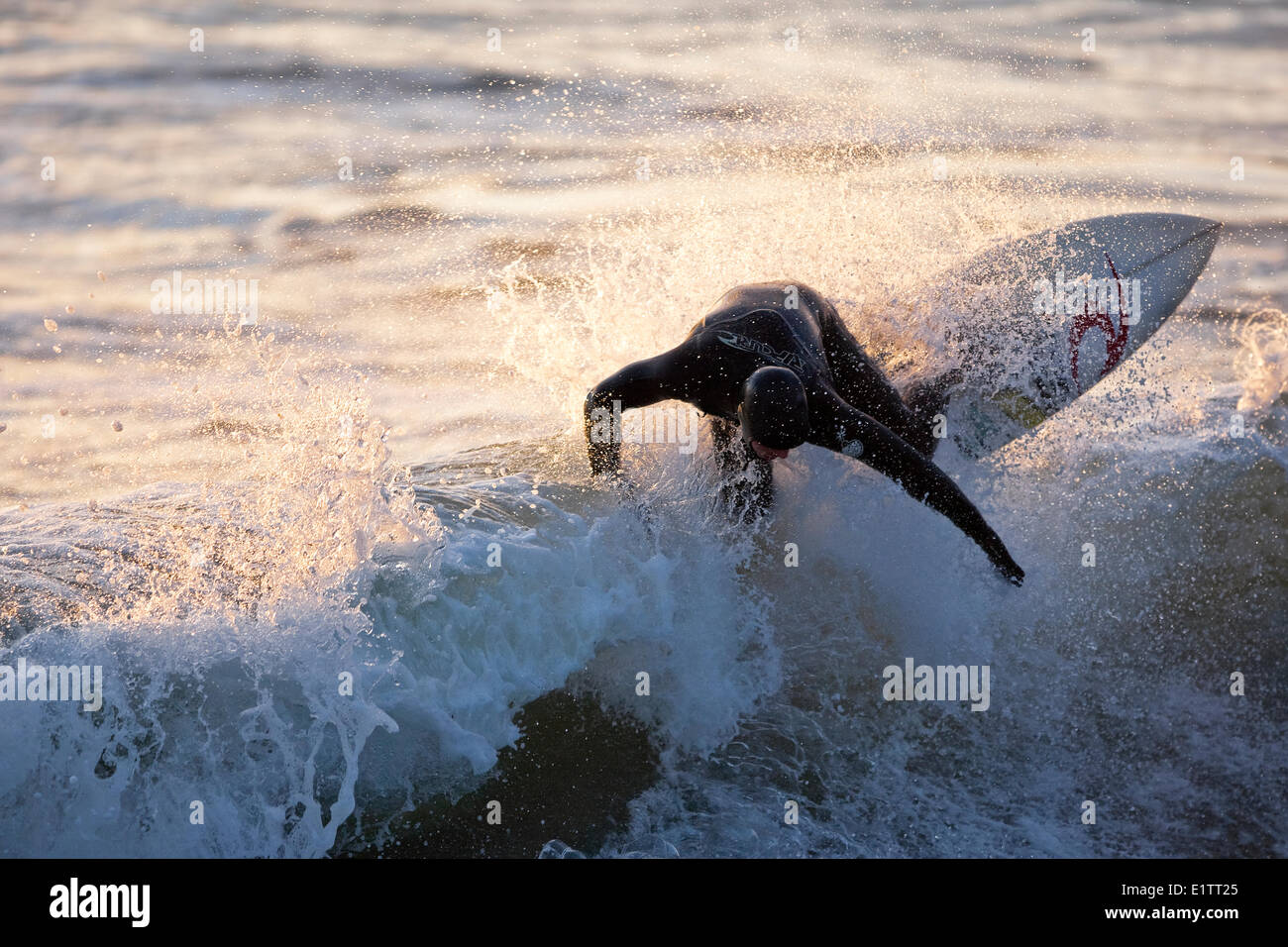 A surfer ripping through the crest of a wave in Rosie Bay, Tofino, Vancouver Island, British Columbia, Canada Stock Photo