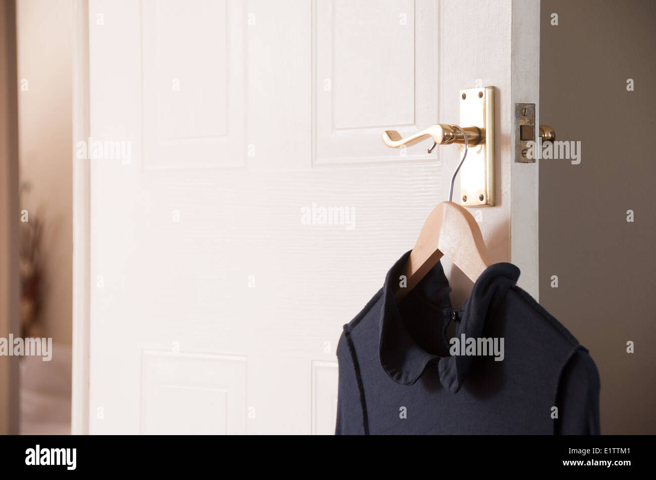 Dress hanging on bedroom door handle Stock Photo