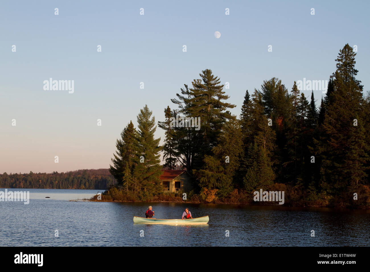Couple paddle canoe on Source Lake, Algonquin Park, Ontario, Canada