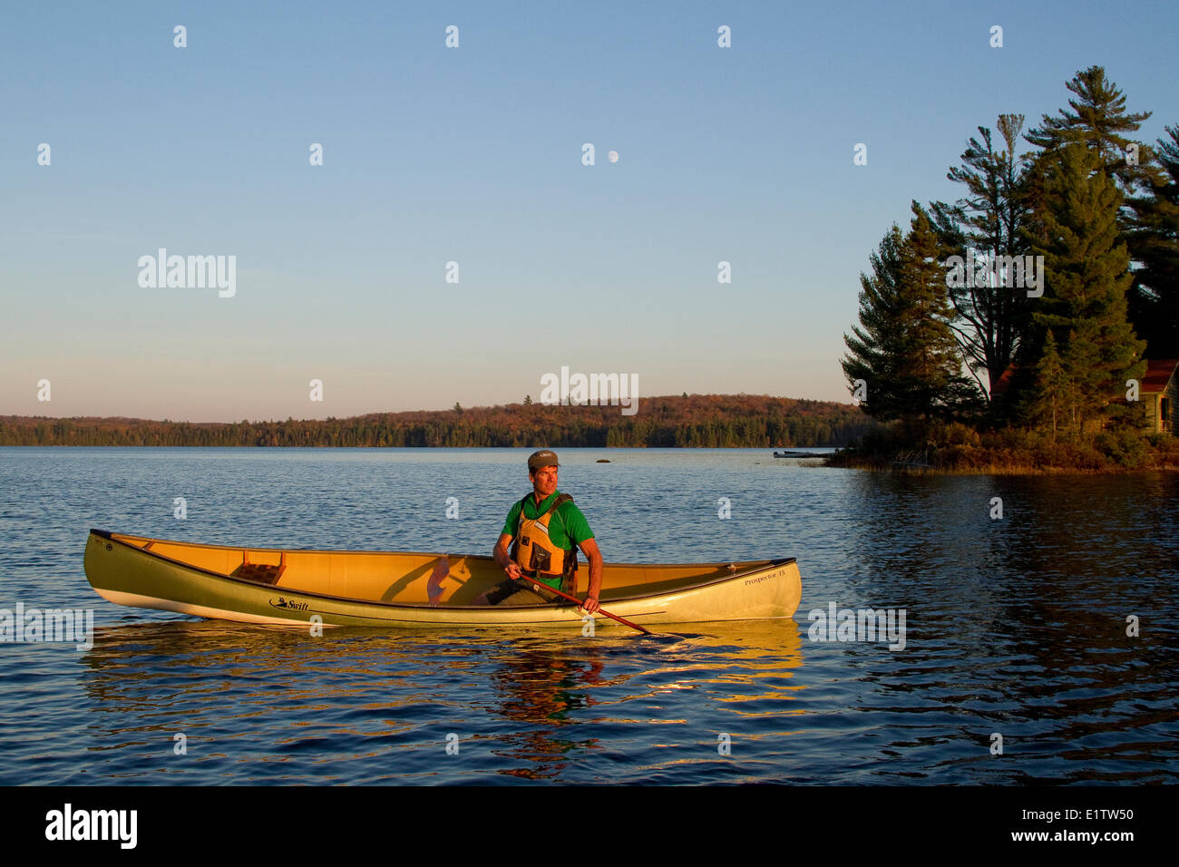 Young man paddles canoe on source lake hires stock photography and