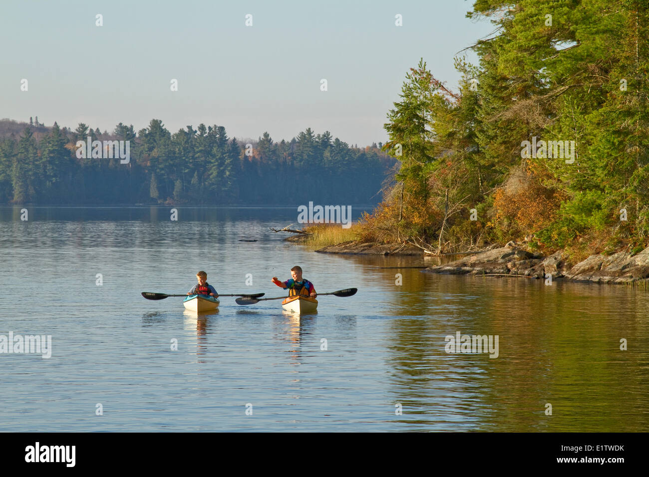 Two young boys enjoy early morning paddle in kayaks on Source Lake, Algonquin Park, Ontario, Canada. Stock Photo