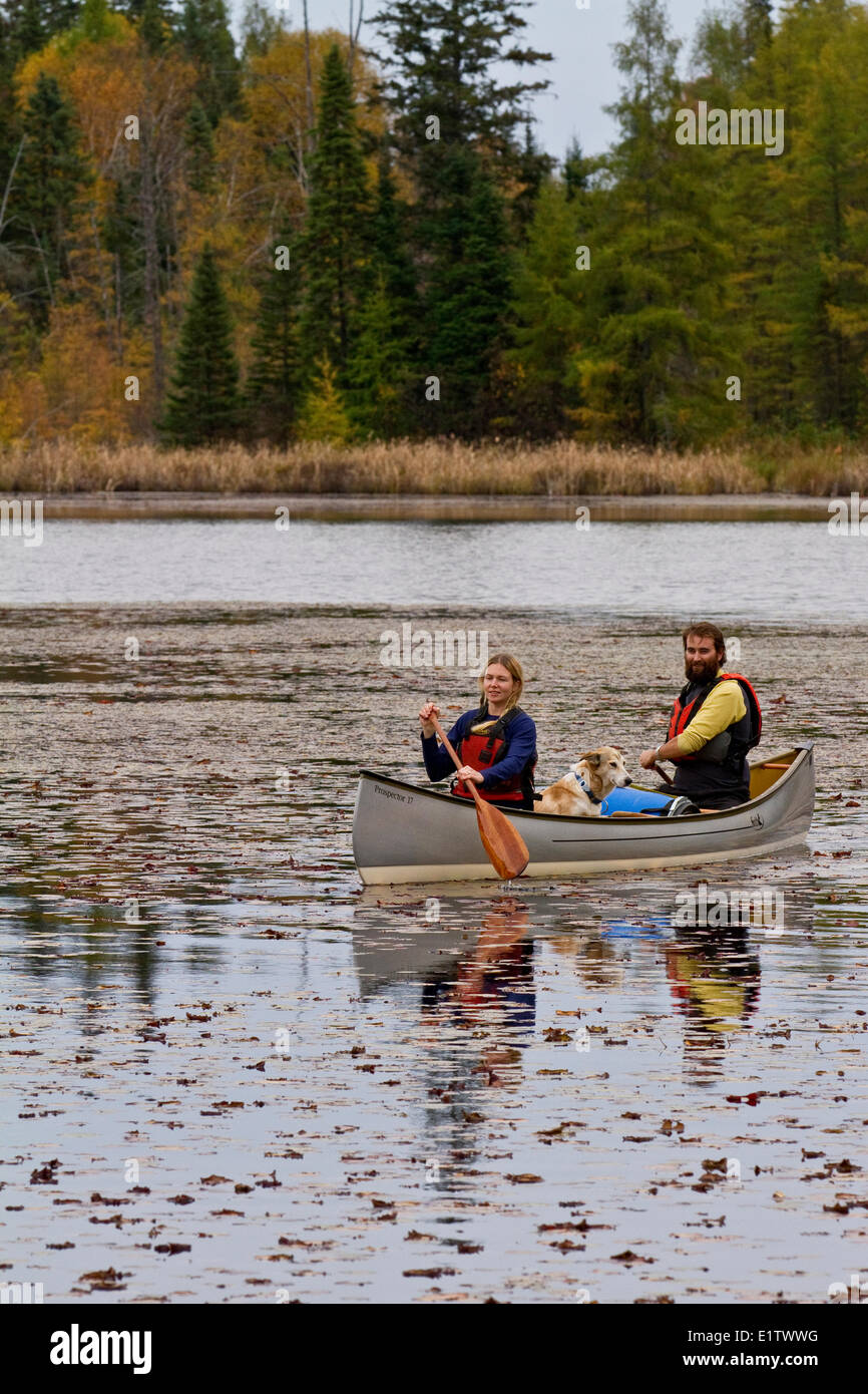 Young couple paddle canoe on small lake in northwestern end of