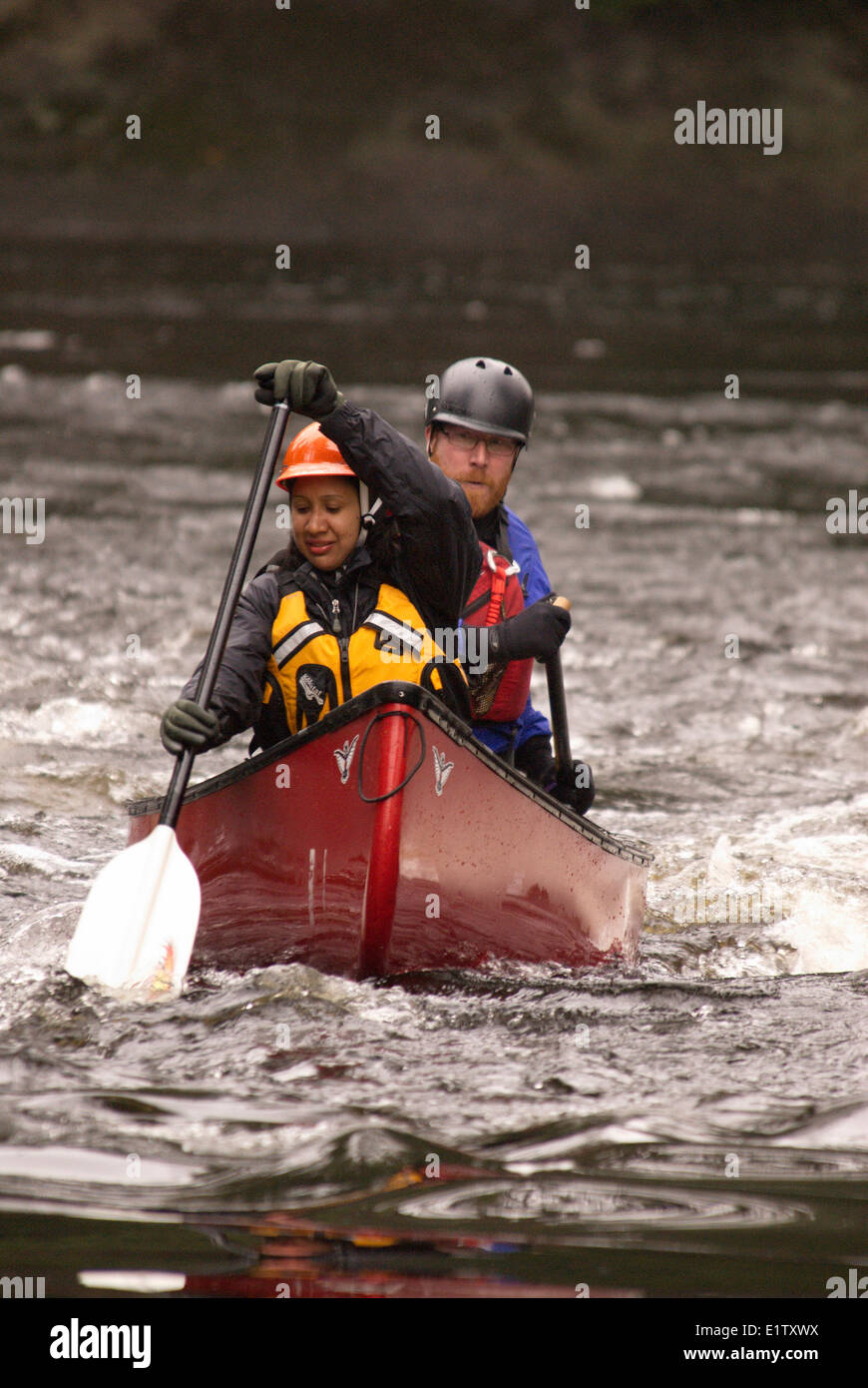 Man and woman whitewater canoeing on the Black River in Muskoka Ontario