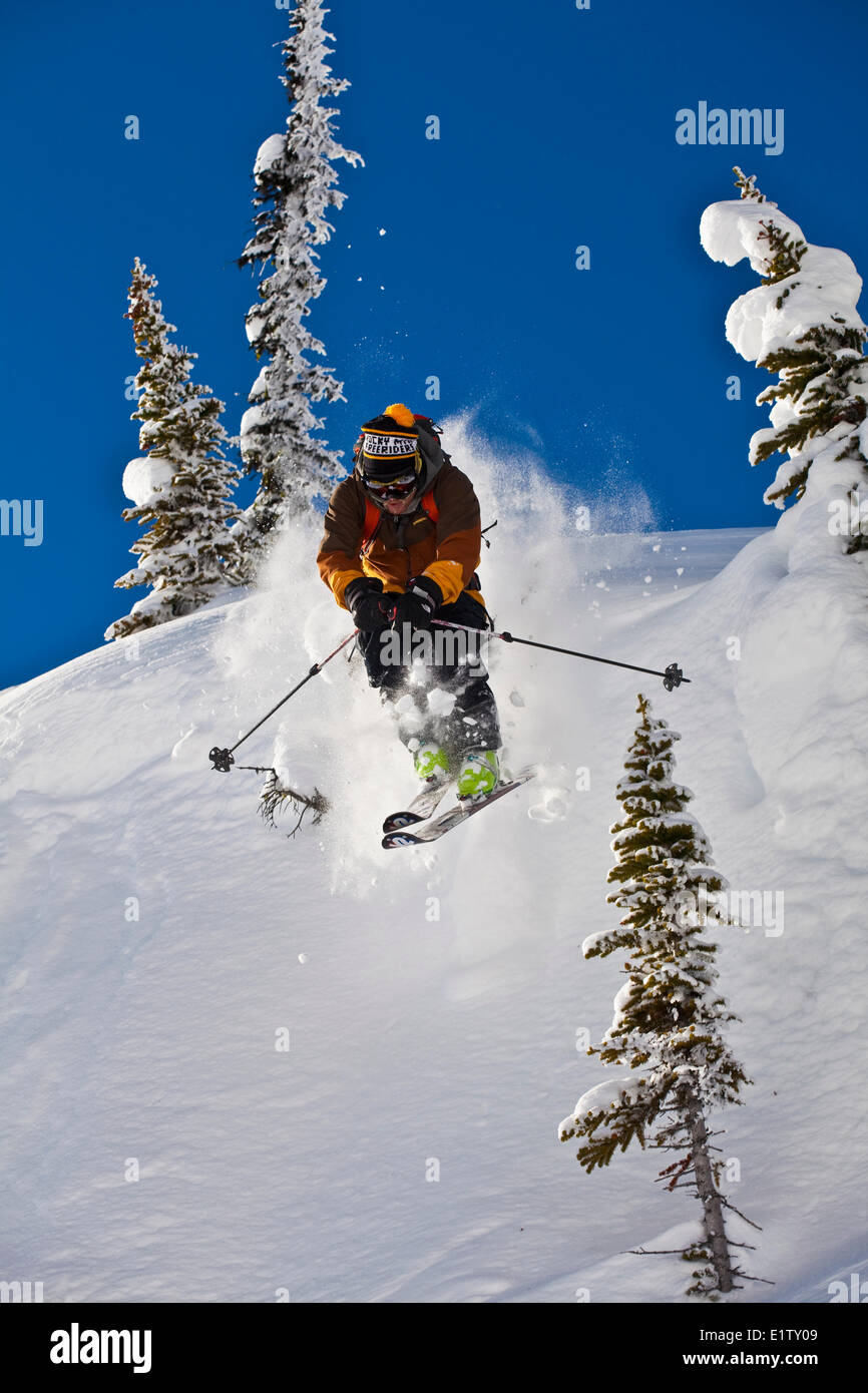 A male backcountry skier drops a cliff while out ski touring, Sol Mountain, Monashee Backcountry, Revelstoke, BC Stock Photo