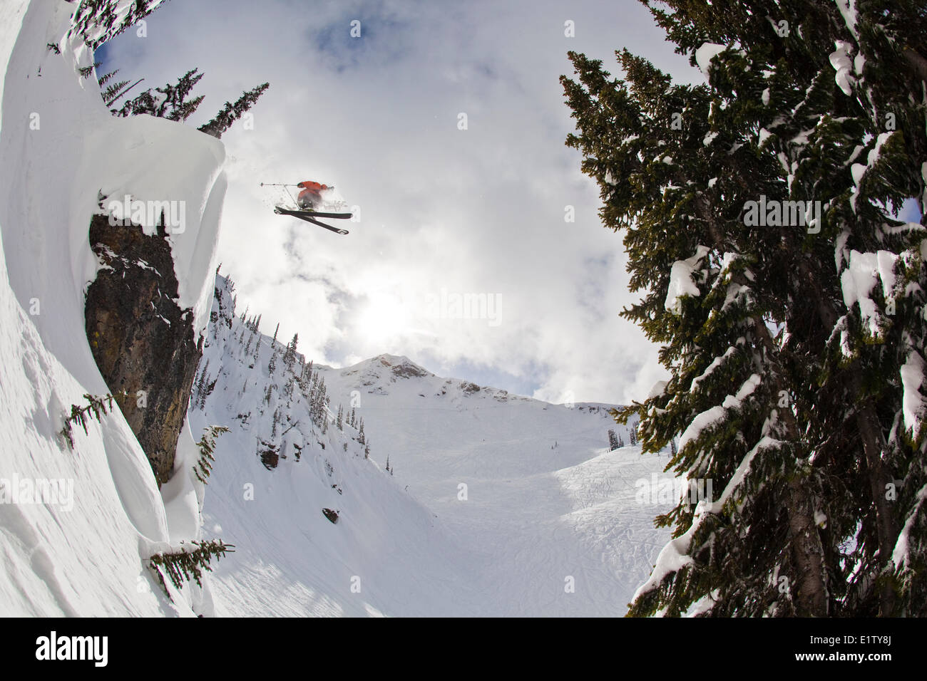 A male freeskier drops a huge cliff at Revelstoke Mtn Resort, BC Stock Photo