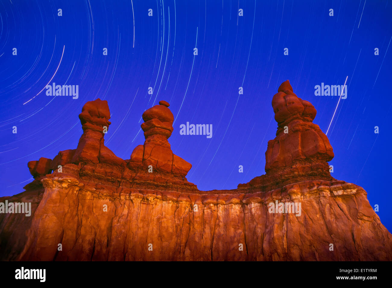 Goblin Valley State Park sandstone formation during night lit up with flash long exposure star trail hoodoos or so called Stock Photo