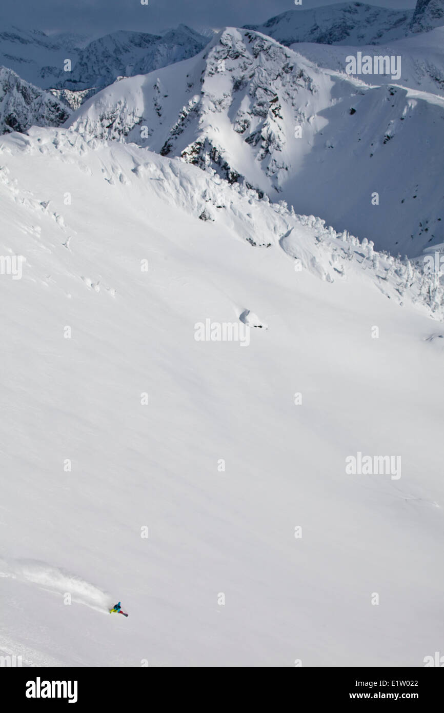 A male backcountry snowboarder sprays a turn. Revelstoke Mountain Resort Backcountry, Revelstoke,  BC Stock Photo