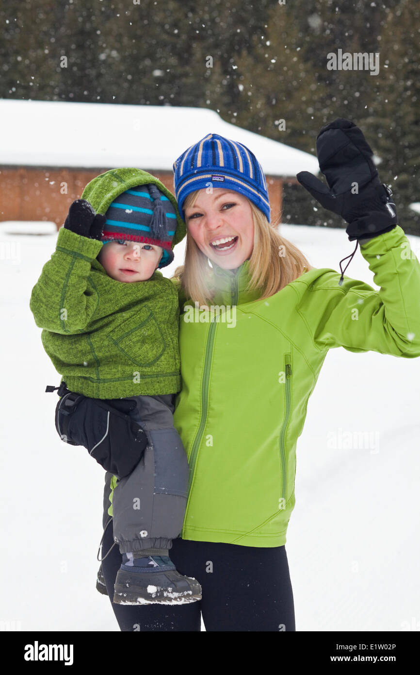 A young mother and baby son snowshoeing in Poccaterra, Peter Lougheed Park, Kananaskis, AB Stock Photo
