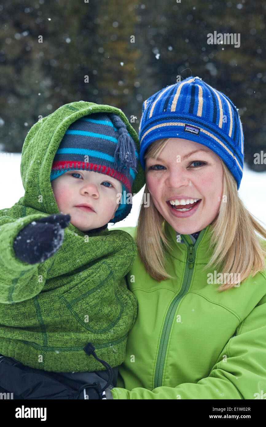 A young mother and baby son snowshoeing in Poccaterra, Peter Lougheed Park, Kananaskis, AB Stock Photo