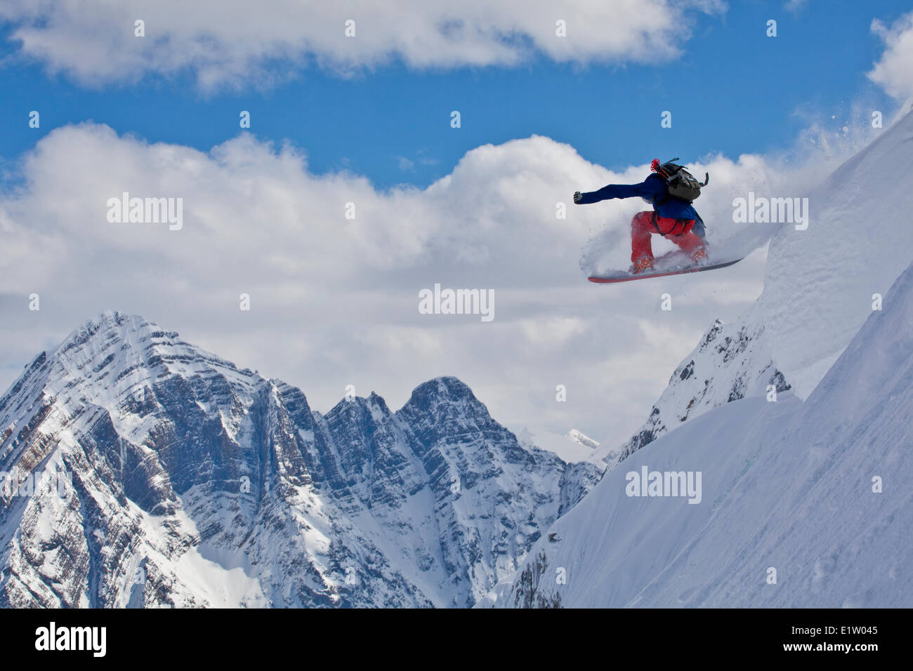 A male backcountry snowboarder airs a pillow with classic canadian