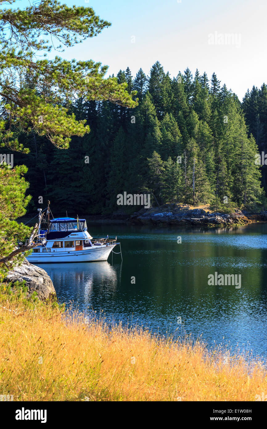 Sunrise illuminates a pleasure boat anchored in the sheltered waters Octupus Island Provincial Marine Park British Columbia Stock Photo