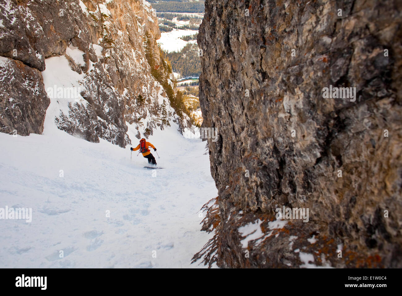 A male backcountry skier rips down a steep coulior close to downtown Banff. Mt. Cory, Banff National Park, AB Stock Photo