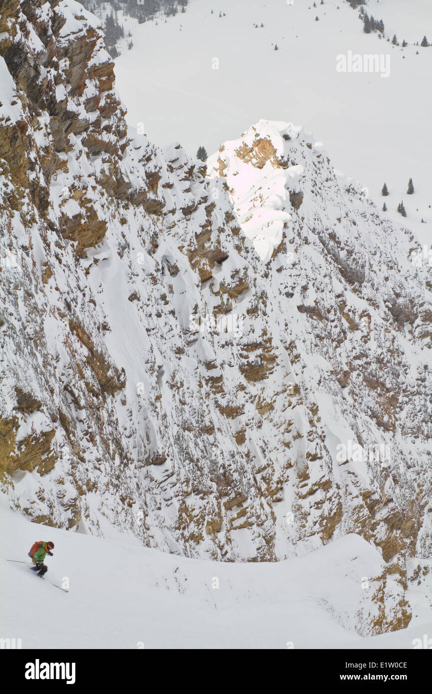 A male backcountry skier descends a steep, exposed coulior on Mt. Chester, AB Stock Photo