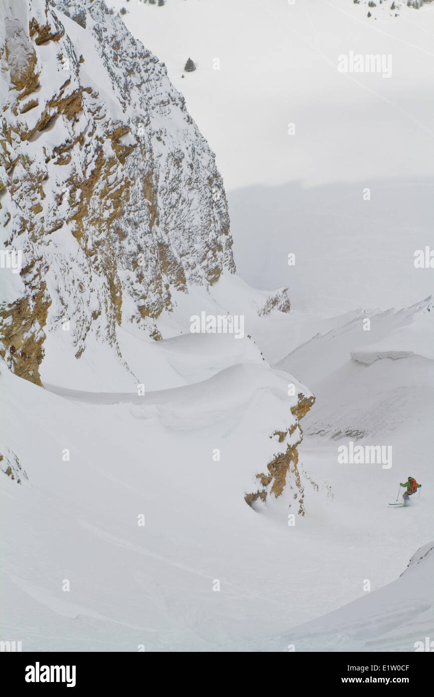 A male backcountry skier descends a steep, exposed coulior on Mt. Chester, AB Stock Photo