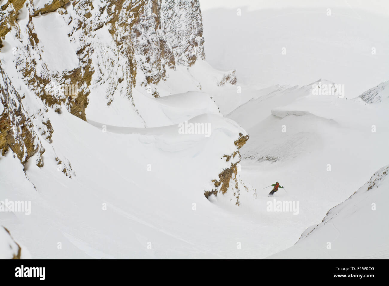 A male backcountry skier descends a steep, exposed coulior on Mt. Chester, AB Stock Photo