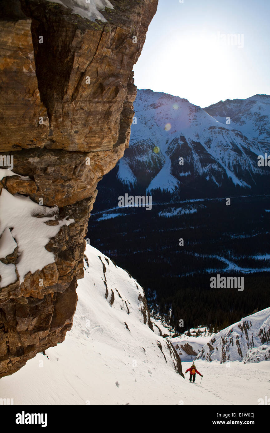 A male backcountry skier bootpacks up a steep and exposed coulior on Mt. Patterson, Icefields Parkway, Banff, AB Stock Photo