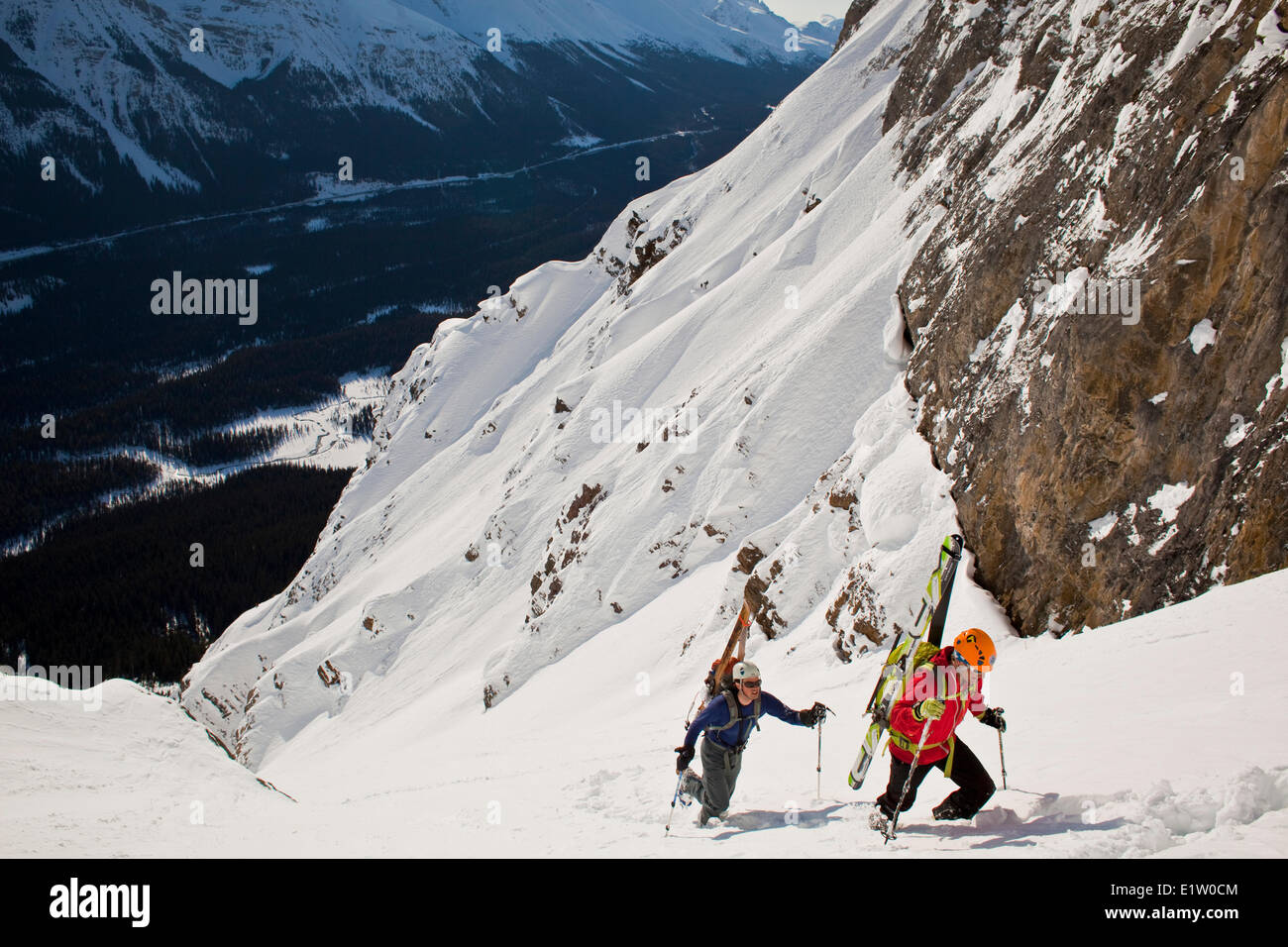 Two male backcountry skiers bootpack up a steep and exposed coulior on Mt. Patterson, Icefields Parkway, Banff, AB Stock Photo
