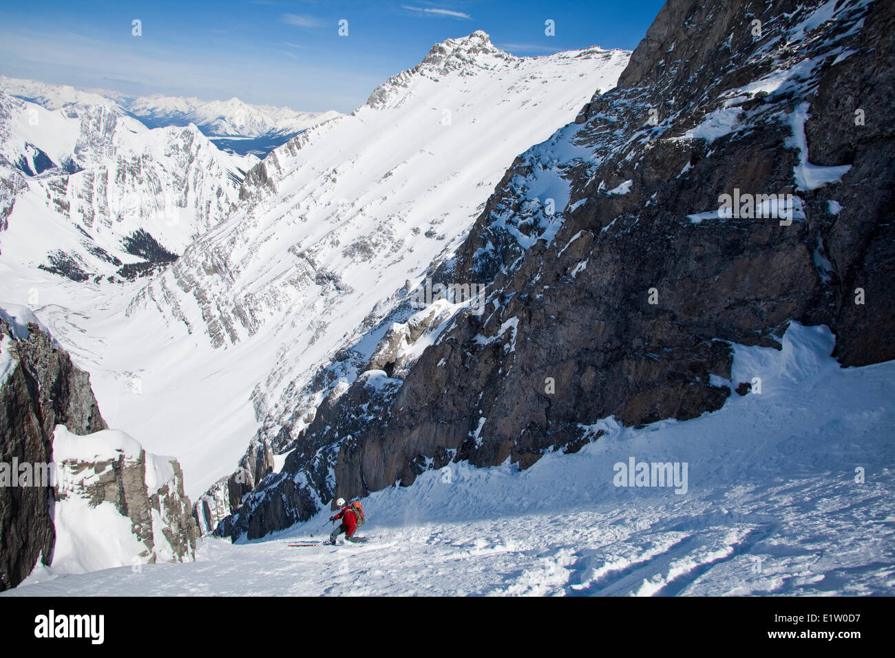 A male backcountry skier on tele skis descends a steep couloir with a unique limestone arch in it. Mt. French Peter Lougheed Stock Photo