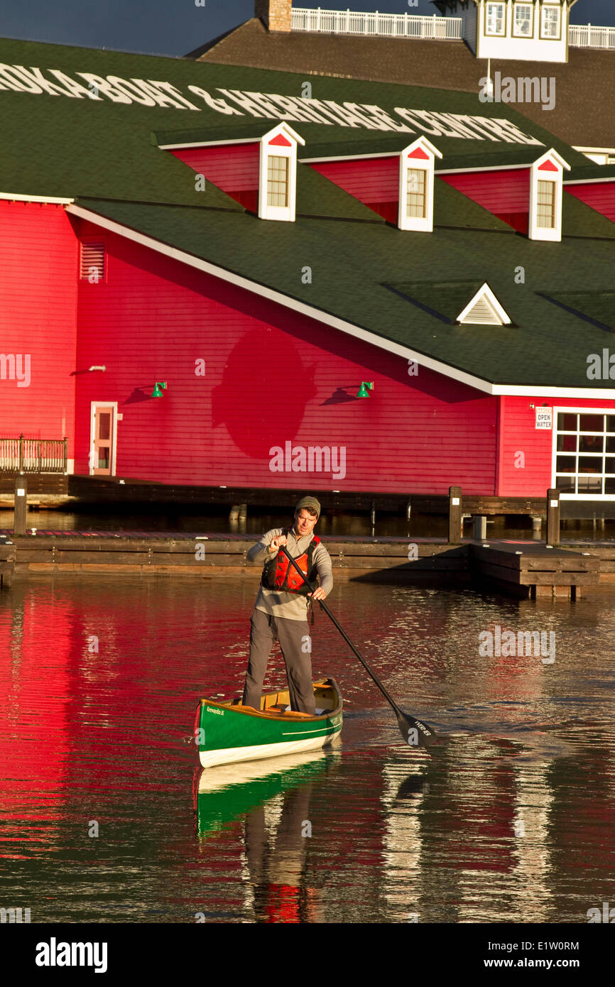 Young man practises standup paddling in canoe on Lake Muskoka