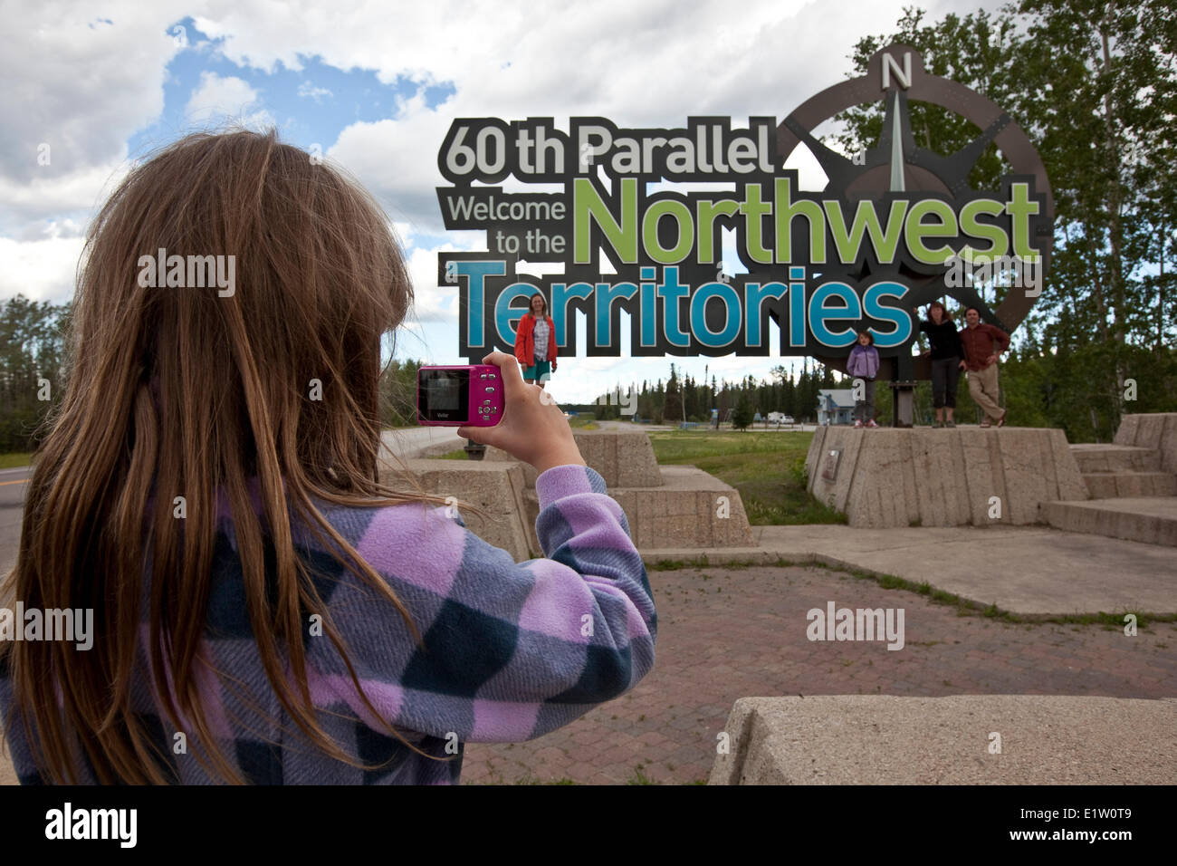 Young girl photographs family at the 60th Parallel border of the Northwest Territories, Canada. Stock Photo